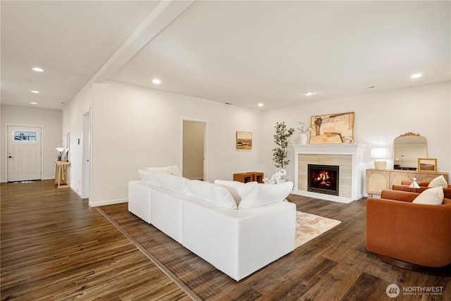 living room with recessed lighting, baseboards, dark wood-style floors, and a tile fireplace