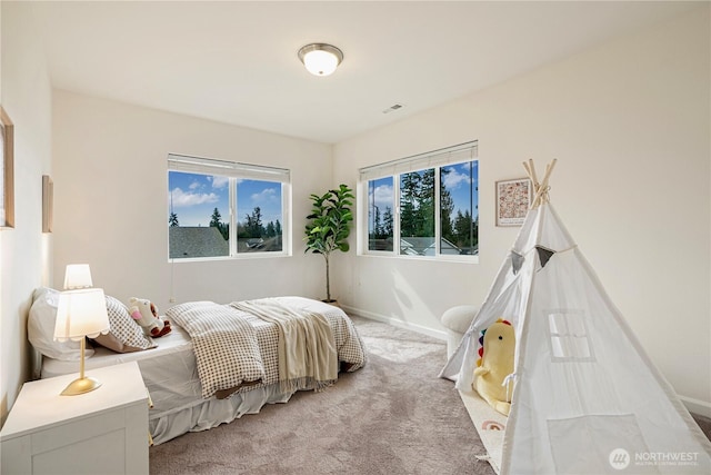 bedroom with visible vents, baseboards, and light carpet