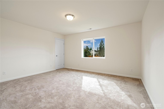 carpeted spare room featuring visible vents and baseboards