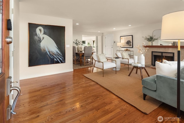 interior space featuring recessed lighting, a fireplace, and wood finished floors