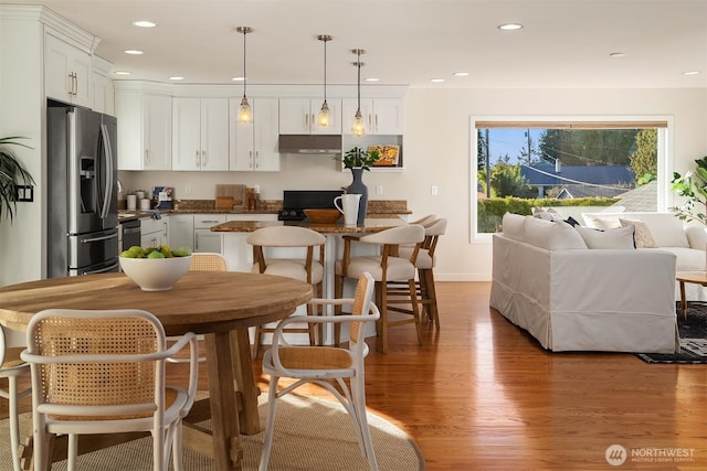 dining room featuring recessed lighting, baseboards, and light wood finished floors