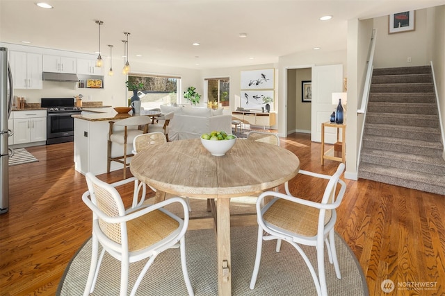 dining space with recessed lighting, stairway, and wood finished floors