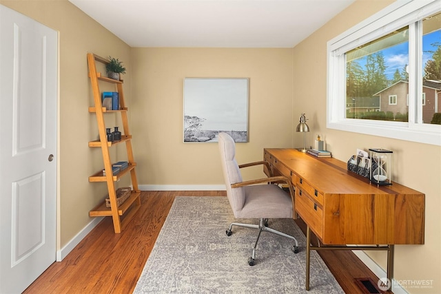 office featuring visible vents, baseboards, and wood finished floors