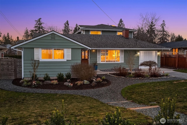 view of front of property featuring a front yard, fence, roof with shingles, concrete driveway, and a garage