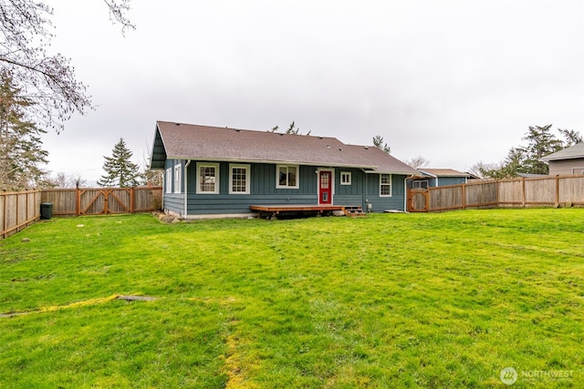 rear view of property with a yard, a fenced backyard, and a shingled roof