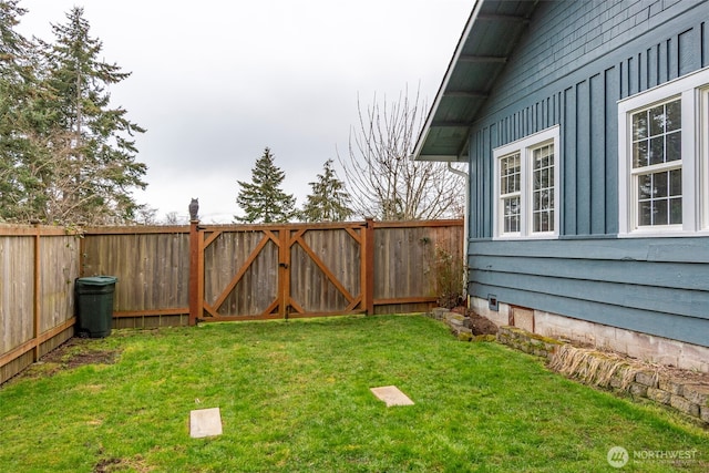 view of yard featuring a fenced backyard and a gate