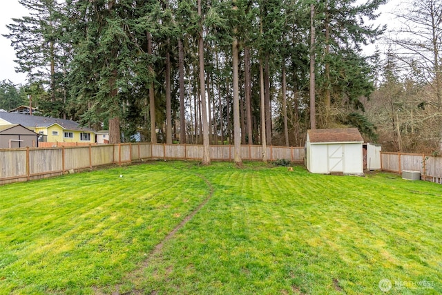 view of yard with a fenced backyard, a storage shed, and an outdoor structure