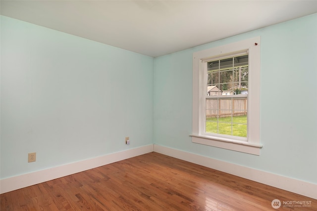 unfurnished room featuring baseboards and wood finished floors