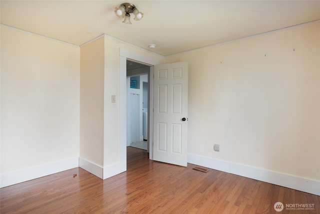 unfurnished room with crown molding, light wood-style floors, and baseboards