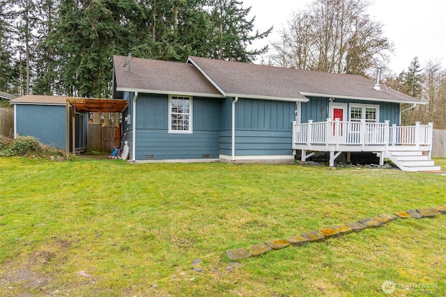 ranch-style house featuring a wooden deck, a shingled roof, a front lawn, crawl space, and board and batten siding