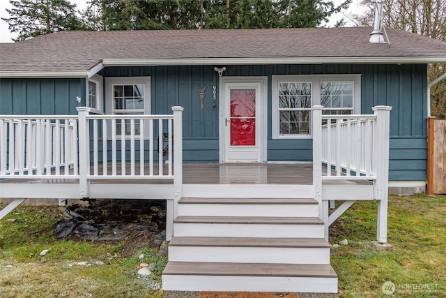 doorway to property featuring a porch, board and batten siding, and a shingled roof