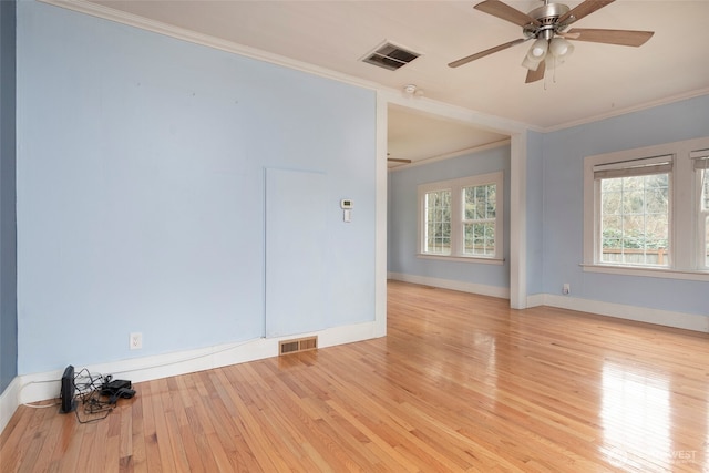 unfurnished room with visible vents, wood-type flooring, ceiling fan, and ornamental molding