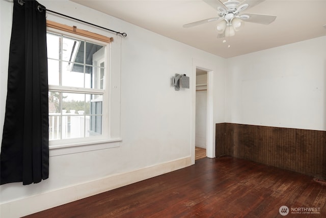 spare room with baseboards, ceiling fan, and wood finished floors