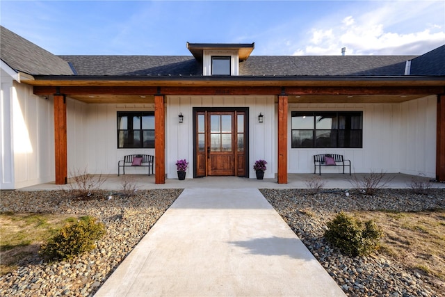 property entrance featuring a porch, board and batten siding, and a shingled roof