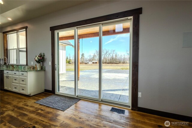 entryway featuring a sink, baseboards, dark wood finished floors, and visible vents