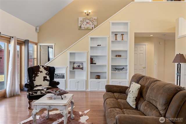 living area with wood finished floors and high vaulted ceiling