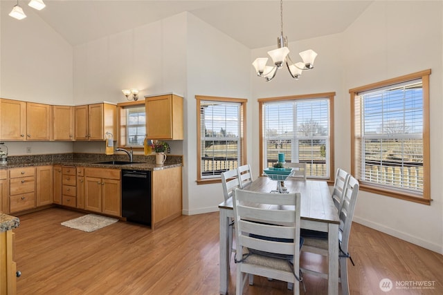 kitchen featuring baseboards, a chandelier, dishwasher, a high ceiling, and light wood-style floors