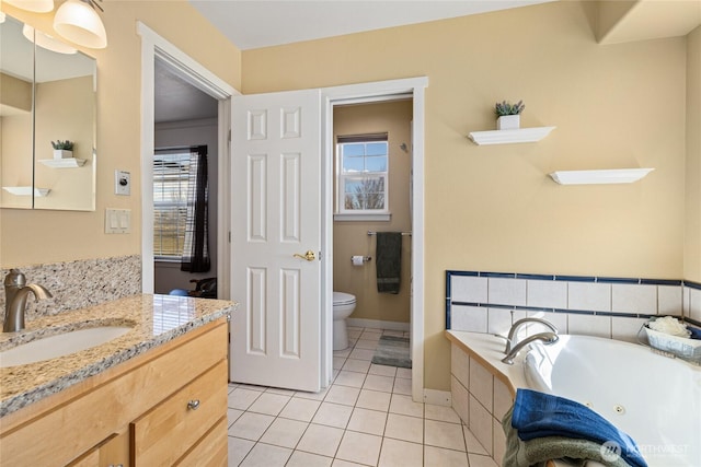 full bath featuring baseboards, toilet, tile patterned floors, a tub with jets, and vanity