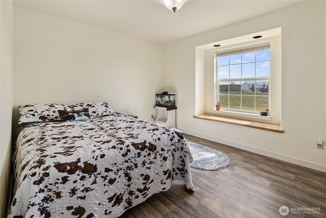 bedroom featuring baseboards and wood finished floors