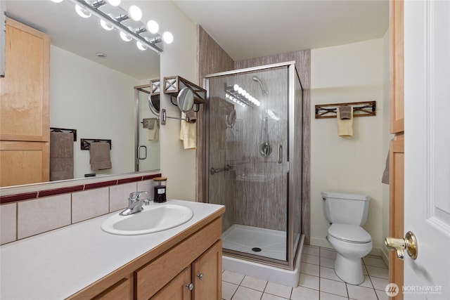 bathroom with tile patterned floors, toilet, a stall shower, and vanity