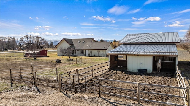 rear view of property featuring an exterior structure, metal roof, and an outdoor structure