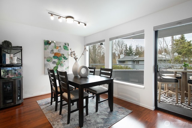 dining area with baseboards and wood finished floors