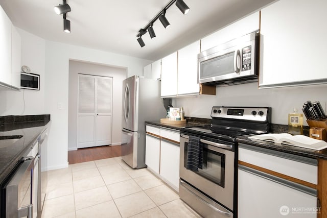 kitchen with light tile patterned floors, white cabinetry, and stainless steel appliances