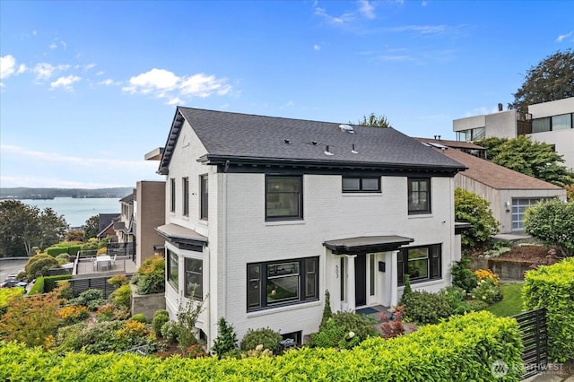 view of front facade with a water view and brick siding