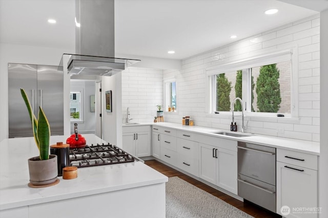 kitchen featuring a sink, stainless steel built in fridge, backsplash, and island exhaust hood