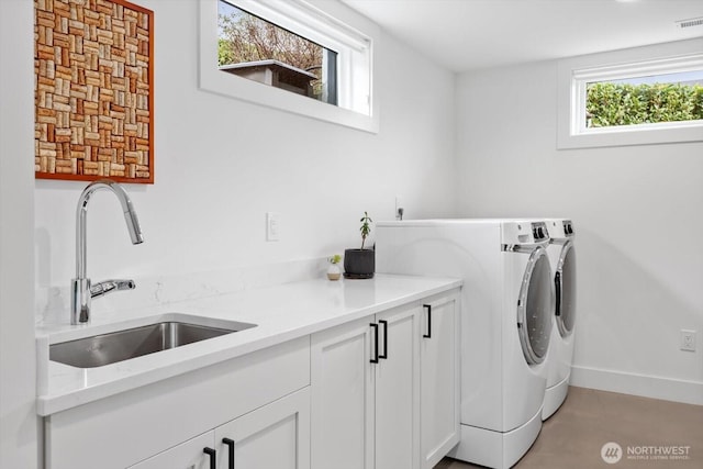 laundry area with visible vents, washer and clothes dryer, a sink, cabinet space, and baseboards