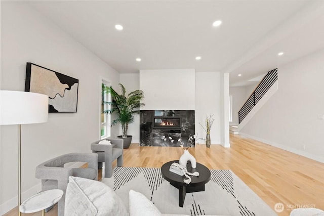 living room with recessed lighting, stairs, wood finished floors, and a fireplace