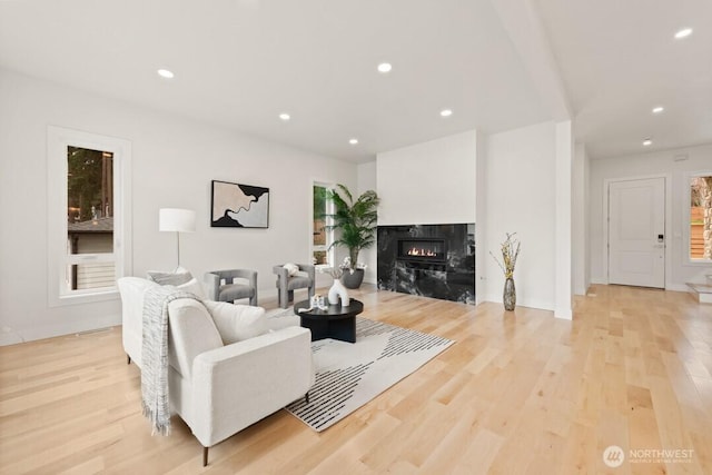 living room featuring recessed lighting, light wood-style flooring, and a fireplace