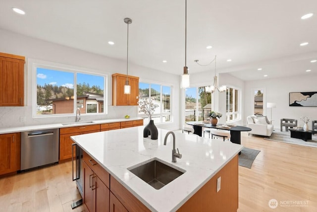 kitchen featuring a sink, stainless steel dishwasher, and brown cabinetry