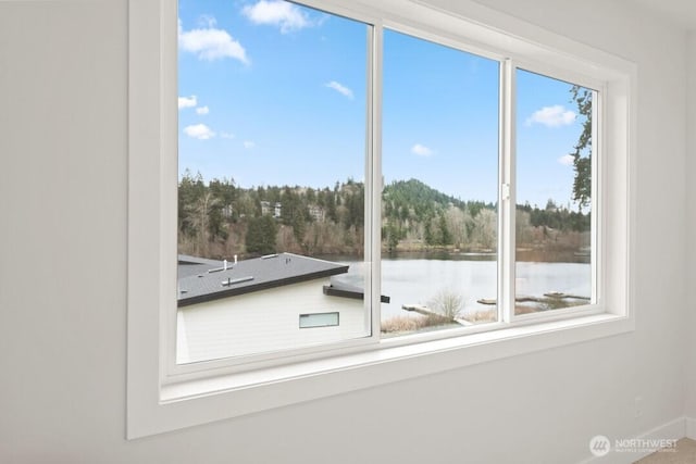 interior space featuring baseboards and a water view