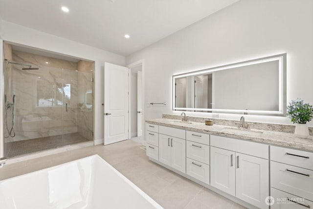 bathroom featuring a sink, a freestanding tub, a stall shower, and double vanity