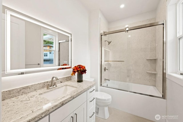 bathroom featuring tile patterned flooring, bath / shower combo with glass door, vanity, and toilet