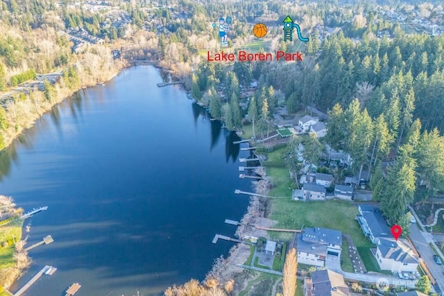 drone / aerial view featuring a water view and a wooded view