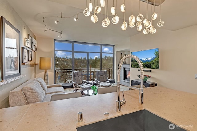 home office featuring track lighting, floor to ceiling windows, and a sink