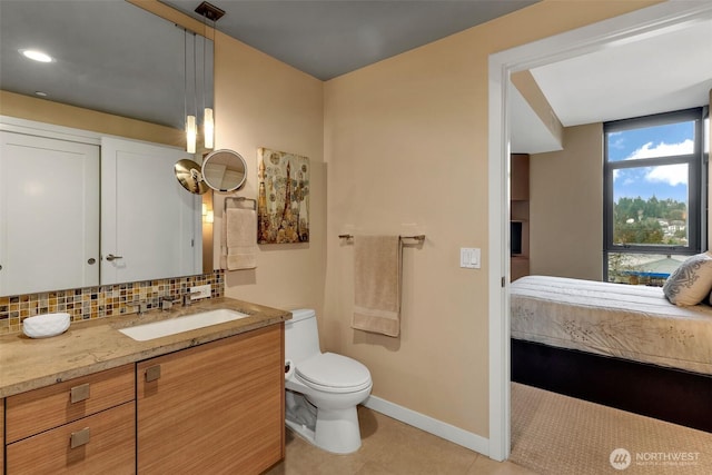 bathroom with tile patterned flooring, backsplash, toilet, vanity, and ensuite bath