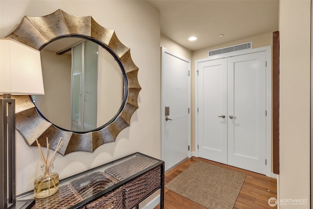 foyer entrance featuring visible vents, recessed lighting, and wood finished floors