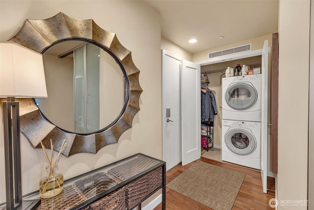 laundry room featuring visible vents, laundry area, recessed lighting, wood finished floors, and stacked washer / drying machine