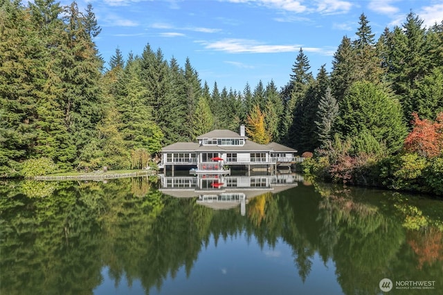 property view of water with a forest view and a boat dock