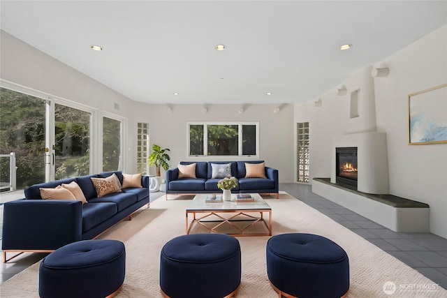 tiled living room with recessed lighting and a glass covered fireplace