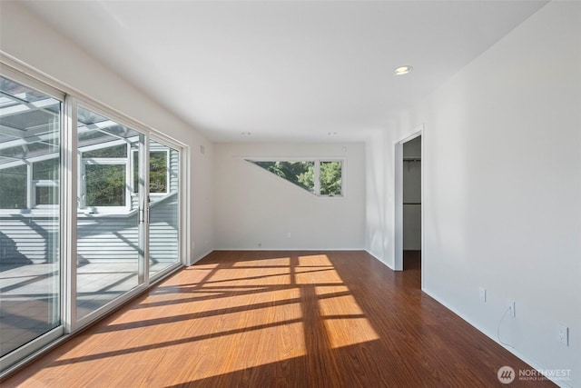 unfurnished room with recessed lighting, wood finished floors, and baseboards