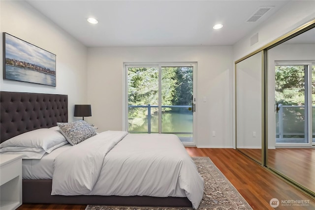 bedroom with recessed lighting, wood finished floors, visible vents, and baseboards