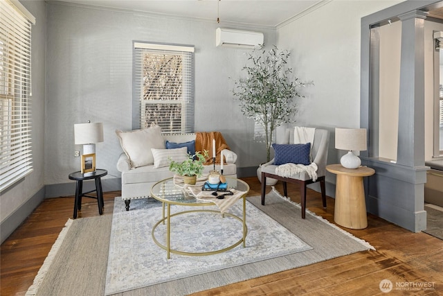 sitting room featuring plenty of natural light, a wall mounted AC, and wood finished floors