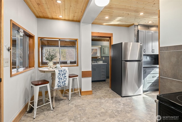 kitchen featuring tasteful backsplash, recessed lighting, wood ceiling, and freestanding refrigerator