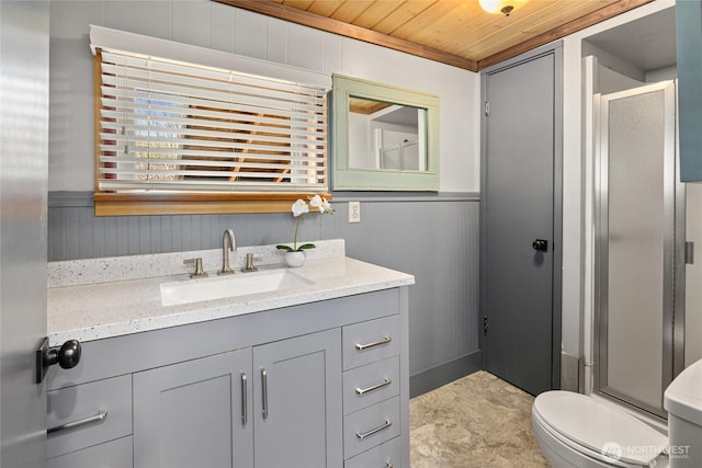full bath with toilet, wainscoting, a stall shower, wooden ceiling, and vanity