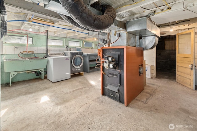 basement featuring independent washer and dryer and a sink
