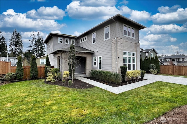 view of front of house featuring brick siding, driveway, a front lawn, and fence